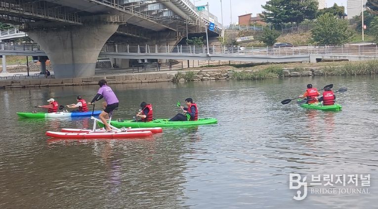 시각장애인과 활동보조사가 동대문구 수상스포츠체험교육장에서 카약 체험하는 모습