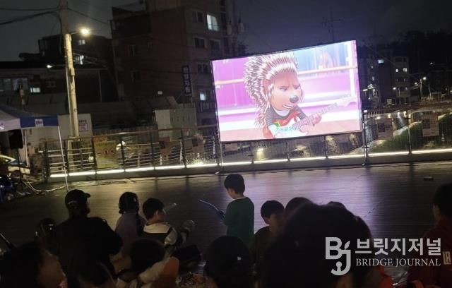 도봉1동 주민들이 누원교 마을마당에서 영화를 보고 있다.