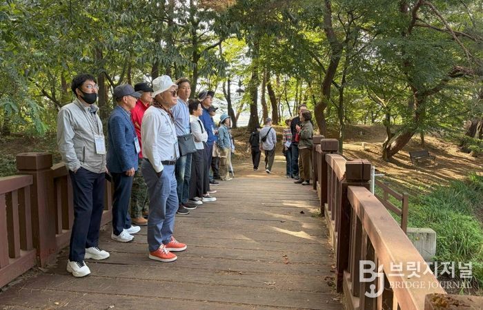 - 25일 열린 밀양 전입자 웰컴투어에서 참가자들이 위양지 둘레길을 걸으며 문화관광해설사 설명을 듣고 있다.