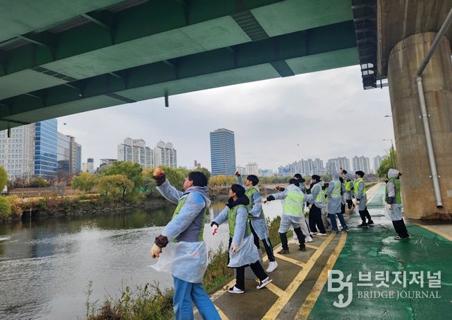서울물재생시설공단‧환경실천연합회 직원들과 시민들이 친환경 정화 물질인 EM 흙공을 안양천에 던지고 있다.