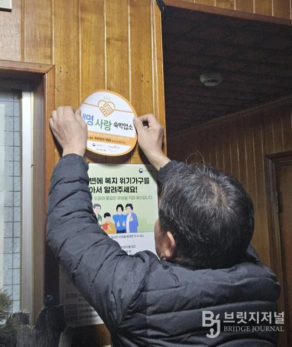 생명사랑 숙박업소용 스티커를 부착하고 있다