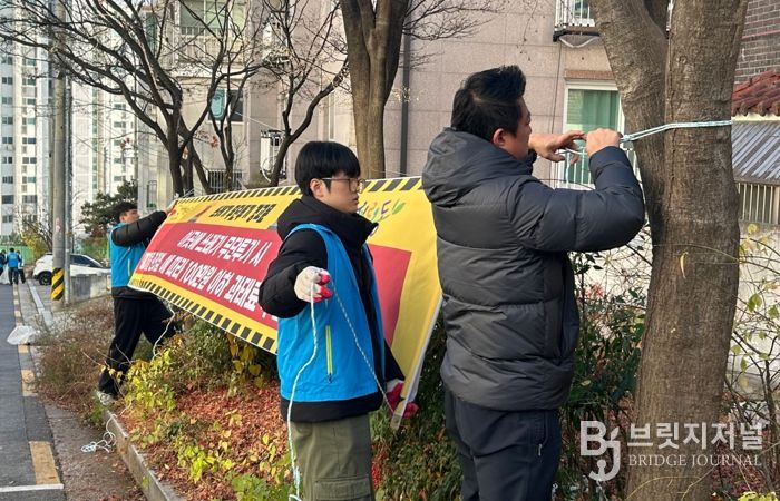 서경대학교 학생들이 무단투기 금지 현수막을 달고 있다.