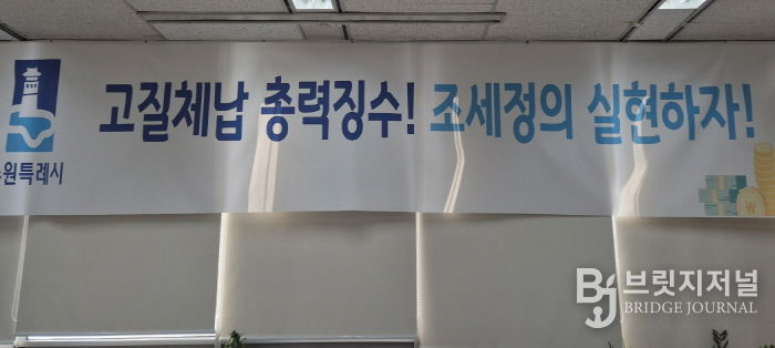 ‘고질체납 총력 징수! 조세정의 실현하자!’ 수원시 징수과 사무실에 걸려 있는 현수막.