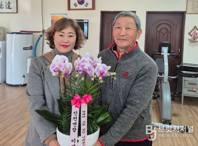 이재이 신전면장이 마을 어르신의 손을 맞잡는 모습