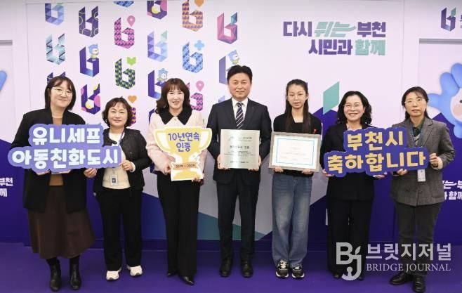 조용익 부천시장과(오른쪽 네 번째), 허정원 아동친화도시조성 추진위원회 부위원장(오른쪽 다섯 번째), 이서현 아동참여위원회 위원장(오른쪽에서 세 번째), 정애경 복지국장(오른쪽 두 번째), 아동보육과 직원들이 유니세프 아동친화도시 인증 기념사진을 찍고 있다.