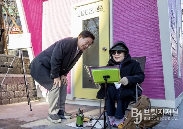 공유화실 앞에서 작가의 그림을 감상하고 있는 박강수 마포구청장