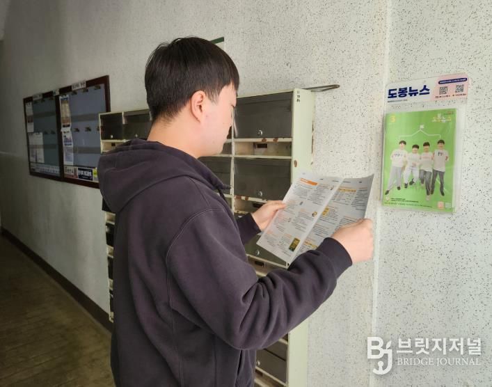 도봉구 주민이 아파트 입구에 설치된 구정 소식지 공동배부함에서 구정 소식지를 꺼내 읽고 있다.