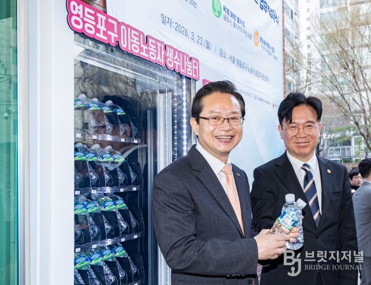 영등포구 이동노동자 쉼터 1호점 앞에 설치된 생수 자판기 앞에서 김영훈 고용노동부 장관과 사진 찍고 있는 최호권 영등포구청장