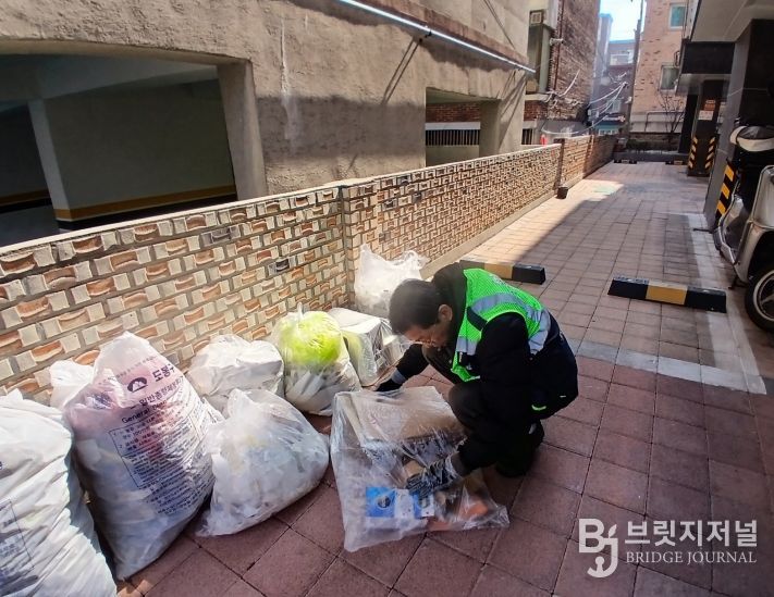 도봉구 무단투기 전담 단속반이 한 빌라에 버려진 무단투기 쓰레기의 주인을 찾기 위해 내용물을 확인하고 있다.