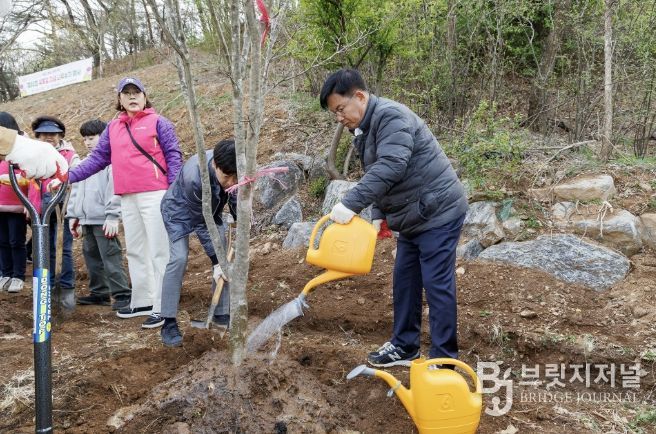 지난해 박강수 마포구청장이 상암 야생화정원에 나무를 식재하고 물을 주고 있다.